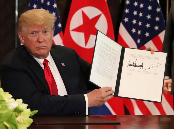 U.S. President Donald Trump shows the document, that he and North Korea's leader Kim Jong Un signed acknowledging the progress of the talks and pledge to keep momentum going, after their summit at the Capella Hotel on Sentosa island in Singapore June 12, 