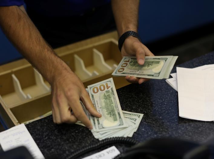 A teller is counting money before betting opens to the public at Monmouth Park Sports Book by William Hill, ahead of the opening of the first day of legal betting on sports in Oceanport, New Jersey, U.S., June 14, 2018. REUTERS/Mike Segar