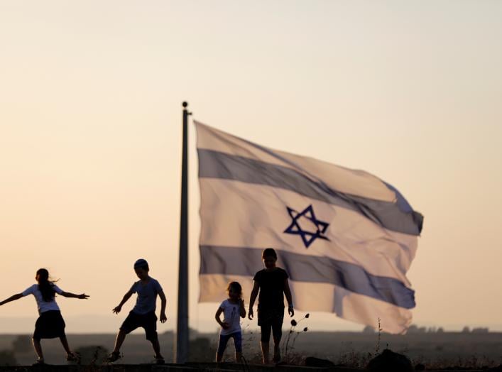 Israeli kids play next to an Israeli flag next to the Israeli Syrian border at the Israeli-occupied Golan Heights, Israel July 23, 2018. REUTERS/Ronen Zvulun