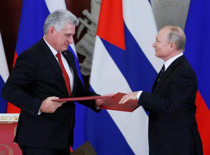 Russian President Vladimir Putin and Cuban President Miguel Diaz-Canel exchange documents following their meeting at the Kremlin in Moscow, Russia November 2, 2018. REUTERS/Maxim Shemetov