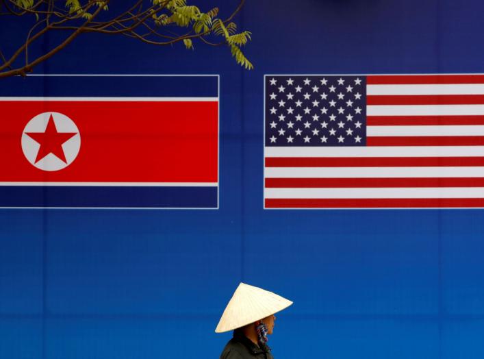 A person walks past a banner showing North Korean and U.S. flags ahead of the North Korea-U.S. summit in Hanoi, Vietnam, February 25, 2019. REUTERS/Kim Kyung-Hoon TPX IMAGES OF THE DAY