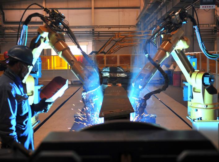 A worker stands next to robotic arms welding pump truck part at a factory of the Foton Loxa Heavy Machinery Co in Zhangjiakou, Hebei province, China May 24, 2019. REUTERS/Stringer 