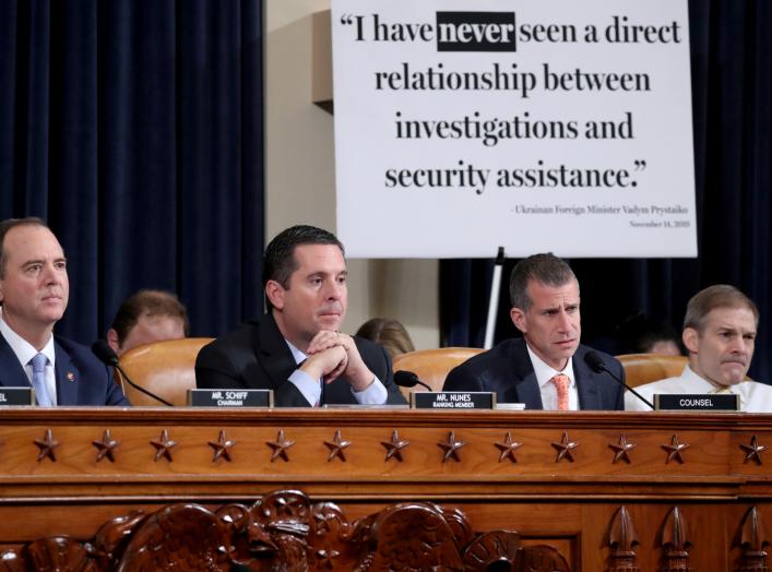 A sign sits behind House Intelligence Chairman Adam Schiff, ranking member Devin Nunes, Republican counsel Steve Castor and Rep. Jim Jordan (R-OH) during a House Intelligence Committee hearing featuring witness Marie Yovanovitch, former U.S. ambassador