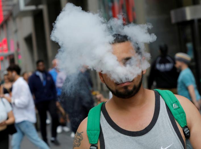 A man uses a vape as he walks on Broadway in New York City, U.S., September 9, 2019. REUTERS/Andrew Kelly