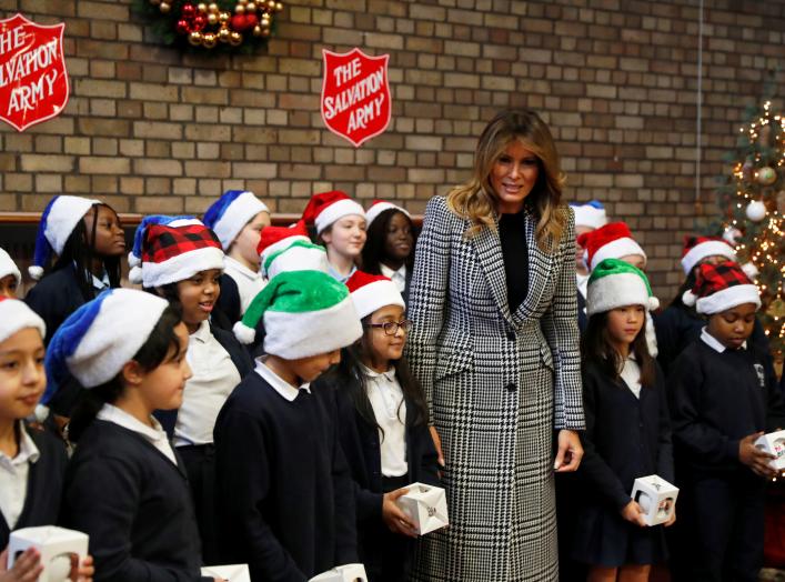 U.S. first lady Melania Trump poses with a children choir after joining local school students and U.S. Marines stationed at the U.S. Embassy, wrapping holiday presents to be donated to the Salvation Army, at the Salvation Army Clapton Center