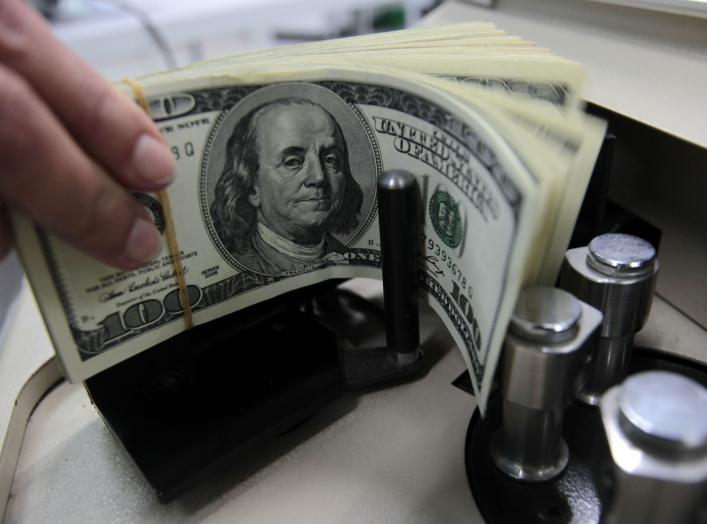 A bank employee counts U.S. hundred dollar bills at Kasikornbank in Bangkok October 12, 2010. The Thai government agreed on Tuesday to impose a 15 percent withholding tax on interest and capital gains earned by foreign investors on Thai bonds, the latest 