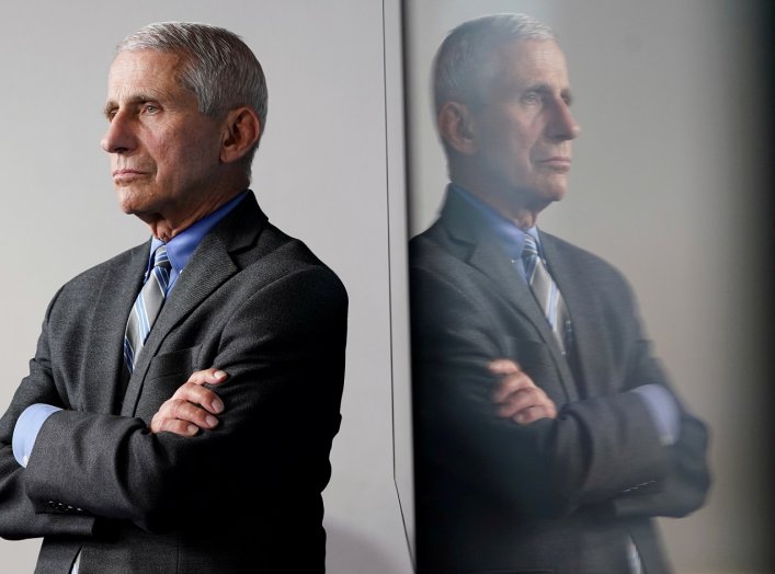 National Institute of Allergy and Infectious Diseases Director Dr. Anthony Fauci is reflected in a video monitor behind him on stage as he listens to the daily coronavirus task force briefing at the White House in Washington, U.S., April 8, 2020. REUTERS/