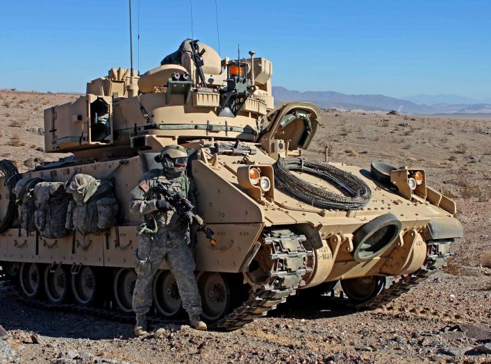 U.S. Army Soldier from the 3rd Armored Brigade Combat Team, 1st Infantry Division pulls security next to a M2 Bradley Infantry Fighting Vehicle during Decisive Action rotation 13-03 on Jan. 19, 2013 at the National Training Center in Fort Irwin, Calif. De