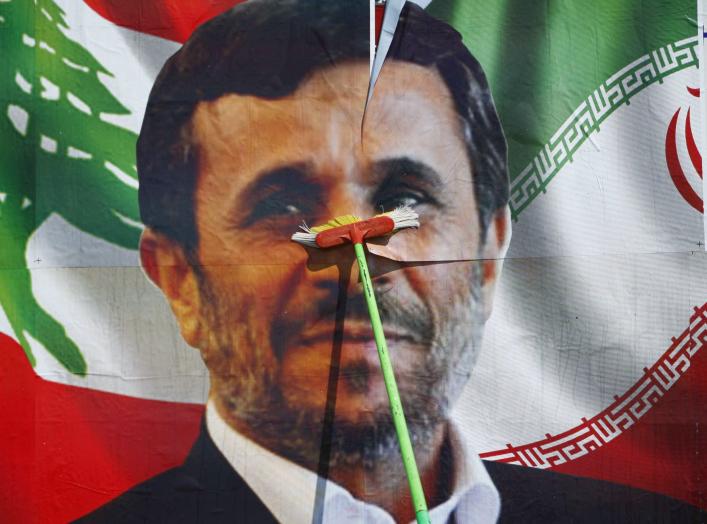 A worker puts up a billboard poster of Iranian President Mahmoud Ahmadinejad in Deir al-Zahrani village at southern Lebanon October 9, 2010. Ahmadinejad plans to visit Lebanon next Wednesday and he is expected to tour villages in southern Lebanon. REUTERS