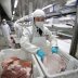 Employees work at a pig slaughtering and pork processing plant in Huaian, Jiangsu province, China April 9, 2020. Picture taken April 9, 2020. China Daily via REUTERS