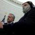 White House Acting Chief of Staff Mark Meadows listens next to a masked soundman and member of the news media during U.S. President Donald Trump's coronavirus response meeting with New Jersey Governor Phil Murphy in the Oval Office at the White House in W