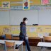 Teacher Nancie Toullec, wearing a protective face mask, walks in a deserted classroom installed to maintain social distancing in a private school open to children of health workers and workers on the coronavirus frontline in Saint-Sebastien-sur-Loire near