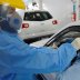 A medical team member wearing a protective suit takes a swab sample from a man at his car to test for the coronavirus disease (COVID-19) at the coronavirus testing center, in the holy city of Najaf, Iraq July 12, 2020. Picture taken July 12, 2020. REUTERS